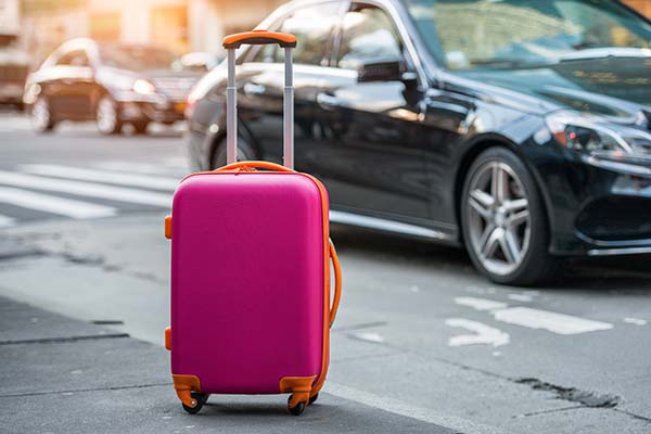 Luggage waiting by the side of a Mercedes Taxi